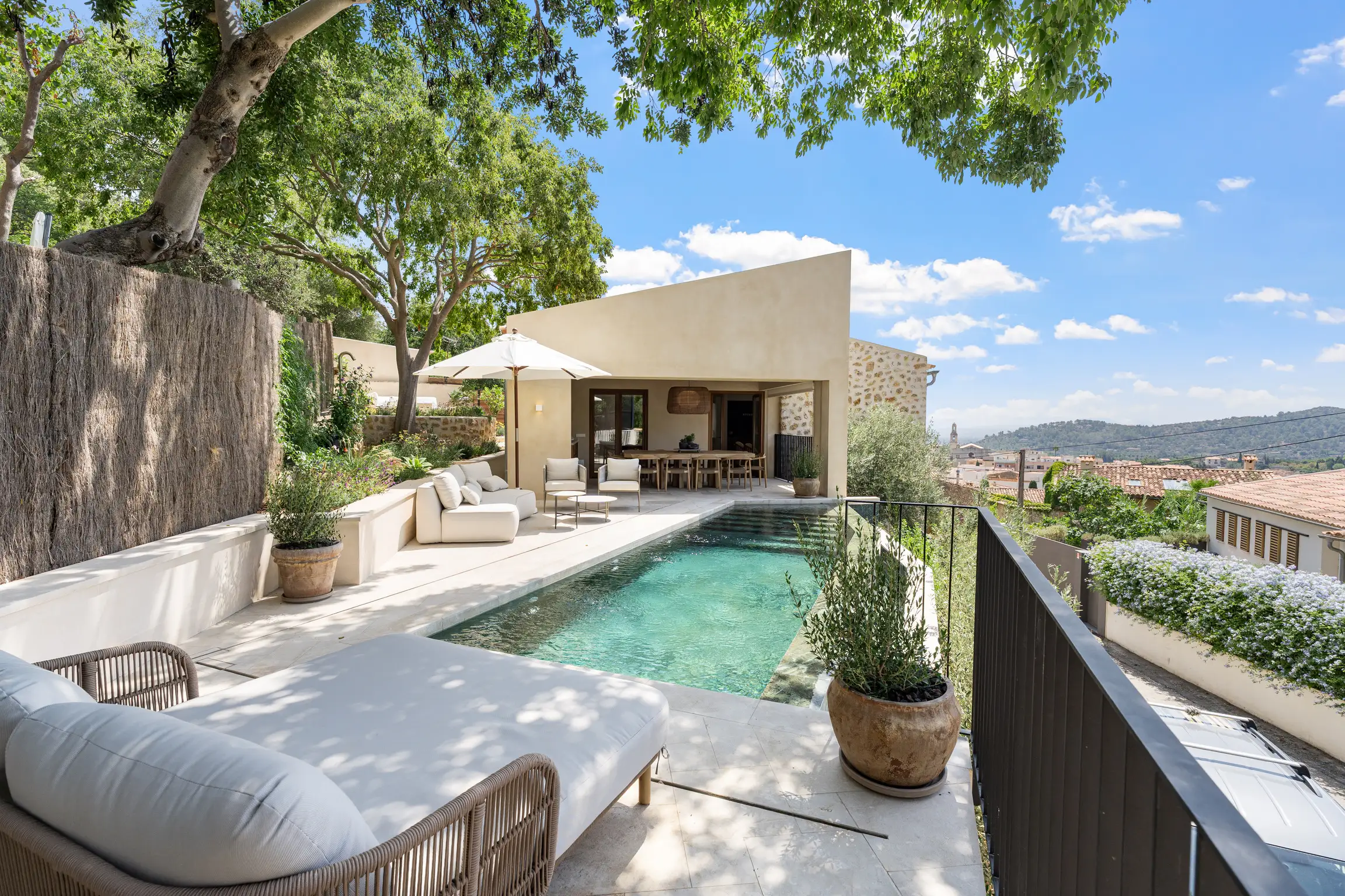 Small modern courtyard with plunge pool, sun loungers, and Mediterranean pots.