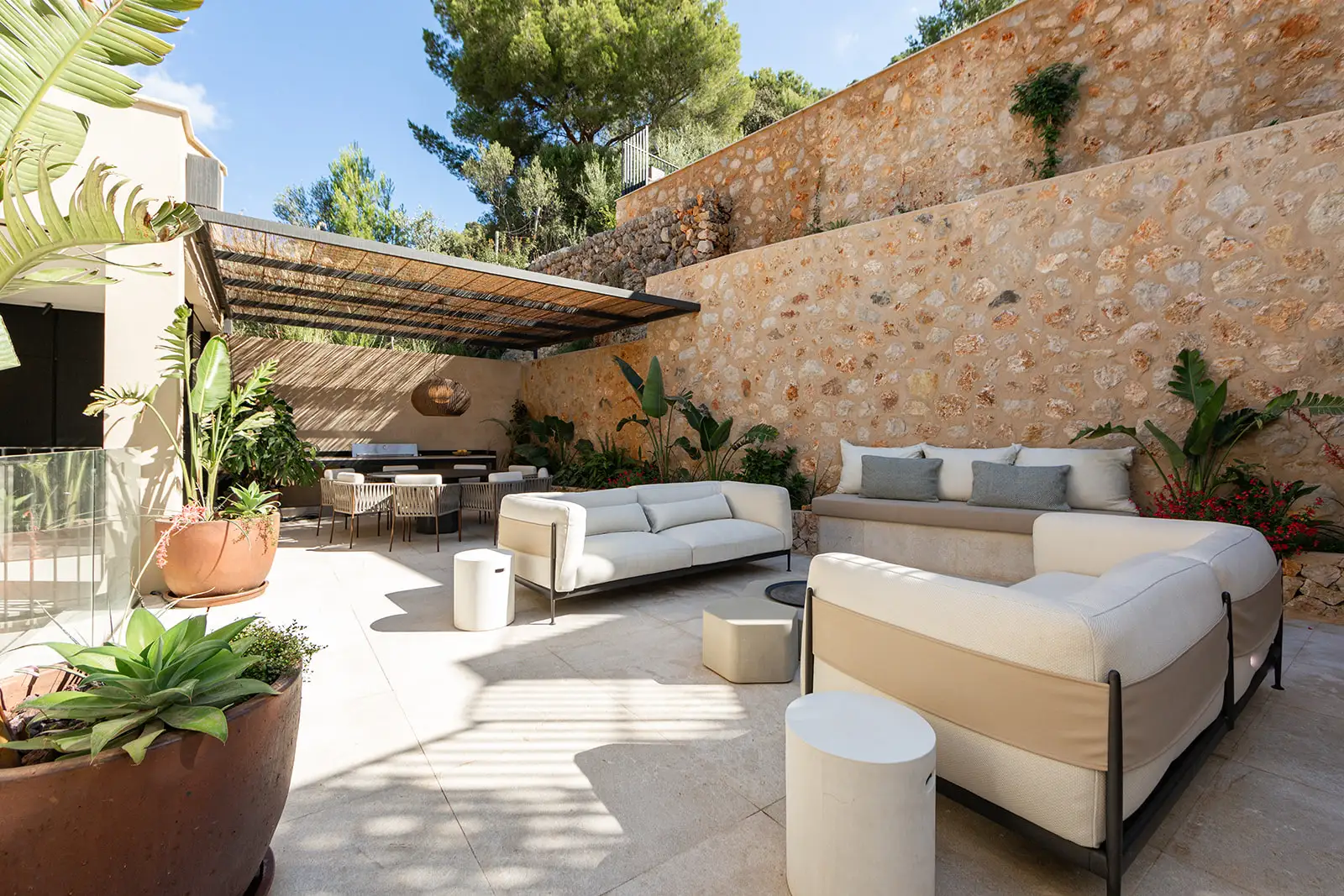 Outdoor living area with modern modular seating and stone wall backdrop.